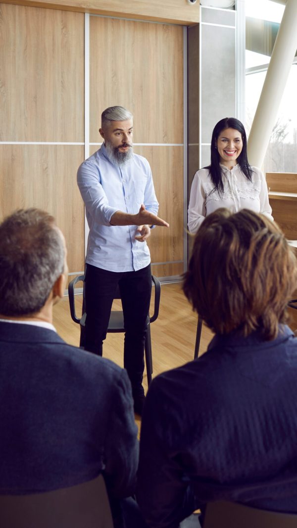 Business coach meeting with team of people, sharing expertise and asking questions Business coach meeting with team of people, sharing expertise and asking questions